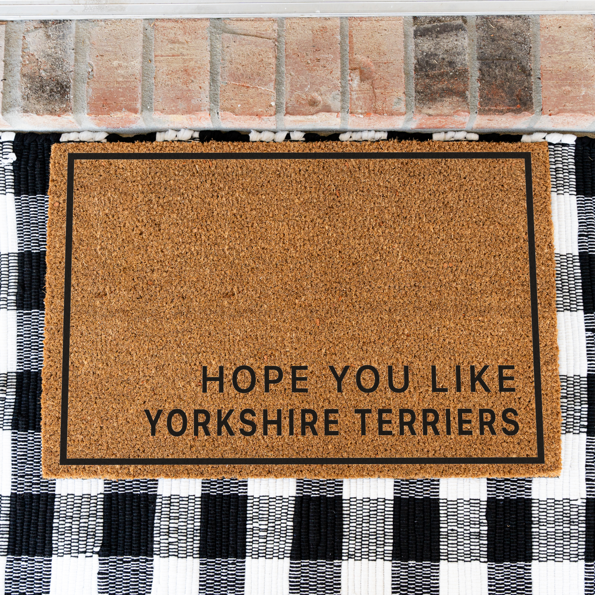 Hope You Like Yorkshire Terriers minimalist coir doormat with a thin black border on a black and white buffalo check rug, close view