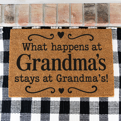 What Happens at Grandma's Stays at Grandma's coir doormat with hearts on a black and white buffalo check rug, close view