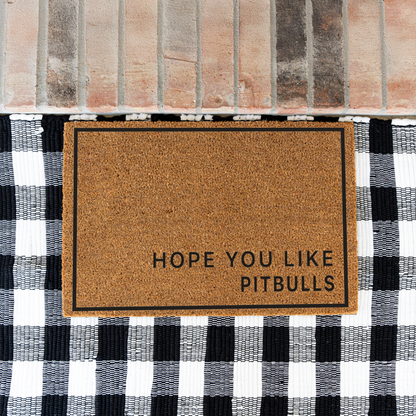 Hope You Like Pitbulls minimalist coir doormat with a thin black border on a black and white buffalo check rug at a brick step