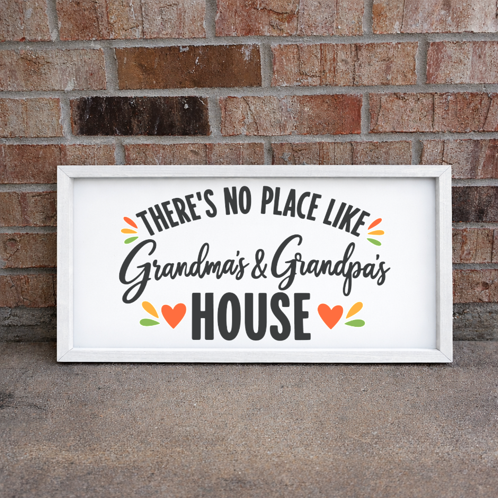 There's No Place Like Grandma's & Grandpa's House wide framed sign with a white frame leaning on a brick wall