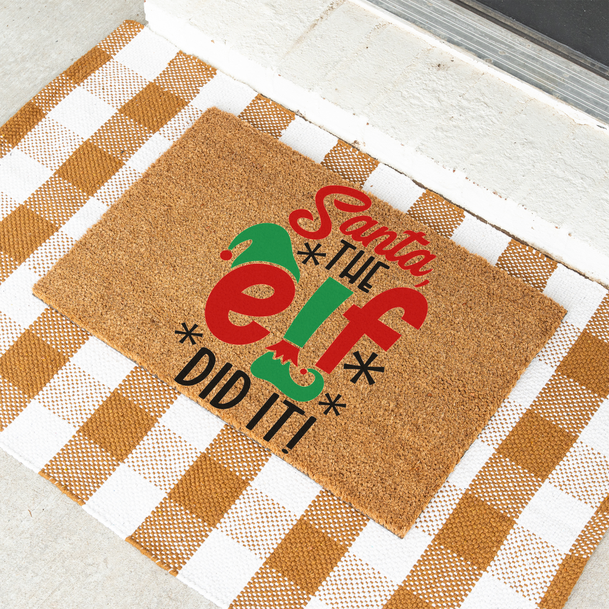 Santa The Elf Did It coir doormat on a tan and white check rug