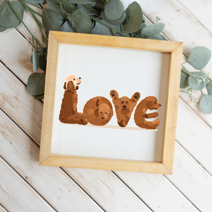 Four red doodles spelling LOVE square framed sign with a natural wood frame on white wood planks with eucalyptus