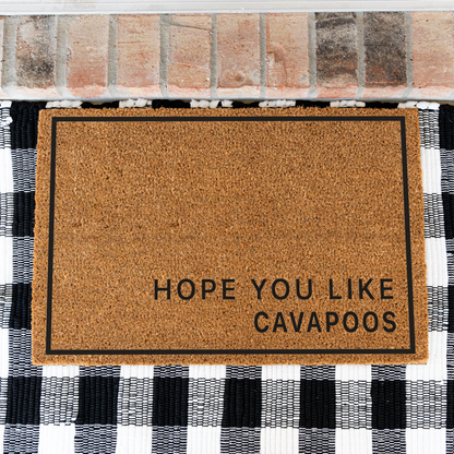 Hope You Like Cavapoos minimalist coir doormat with a thin black border on a black and white buffalo check rug, close view