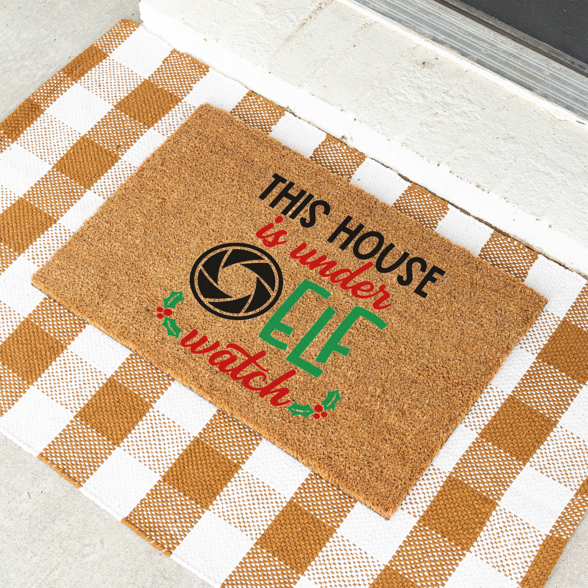 This House Is Under Elf Watch coir doormat on a tan and white check rug