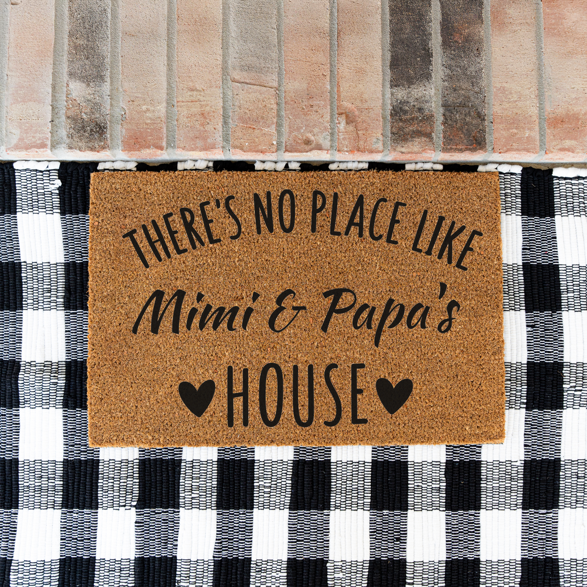 There's No Place Like Mimi & Papa's House coir doormat on a black and white buffalo check rug at a brick step