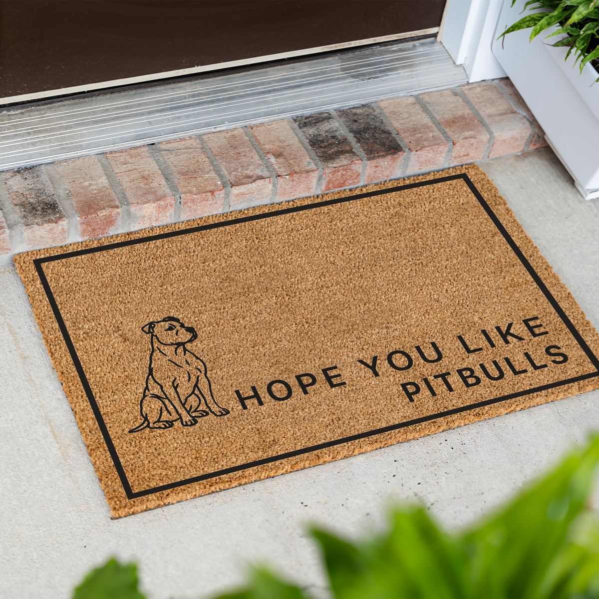 Hope You Like Pitbulls coir doormat with a drawing of a sitting pitbull at an angle on a front porch by a brick step