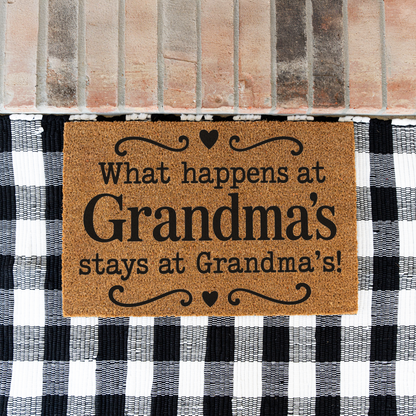 What Happens at Grandma's Stays at Grandma's coir doormat with hearts on a black and white buffalo check rug at a brick step