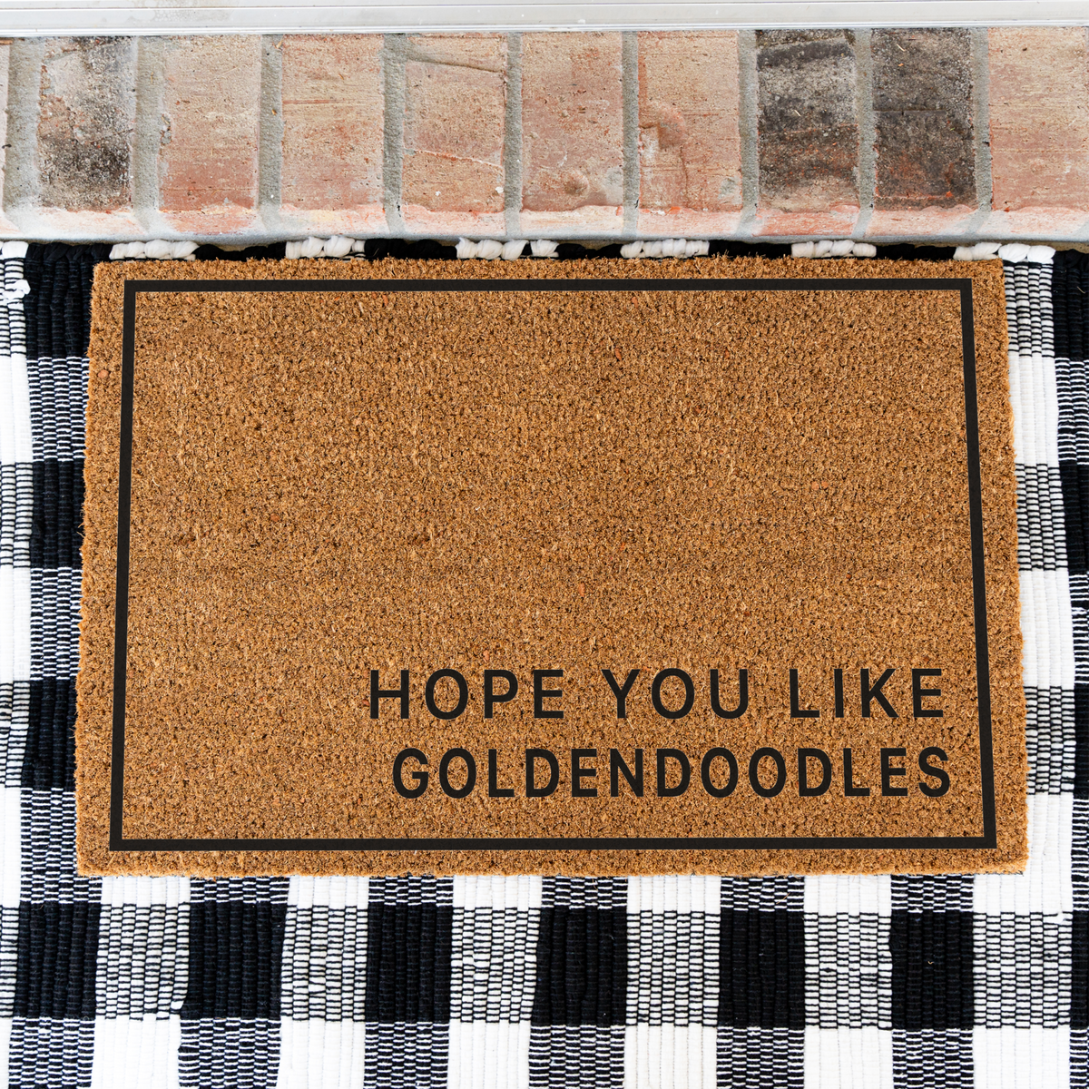 Hope You Like Goldendoodles minimalist coir doormat with a thin black border on a black and white buffalo check rug, close view