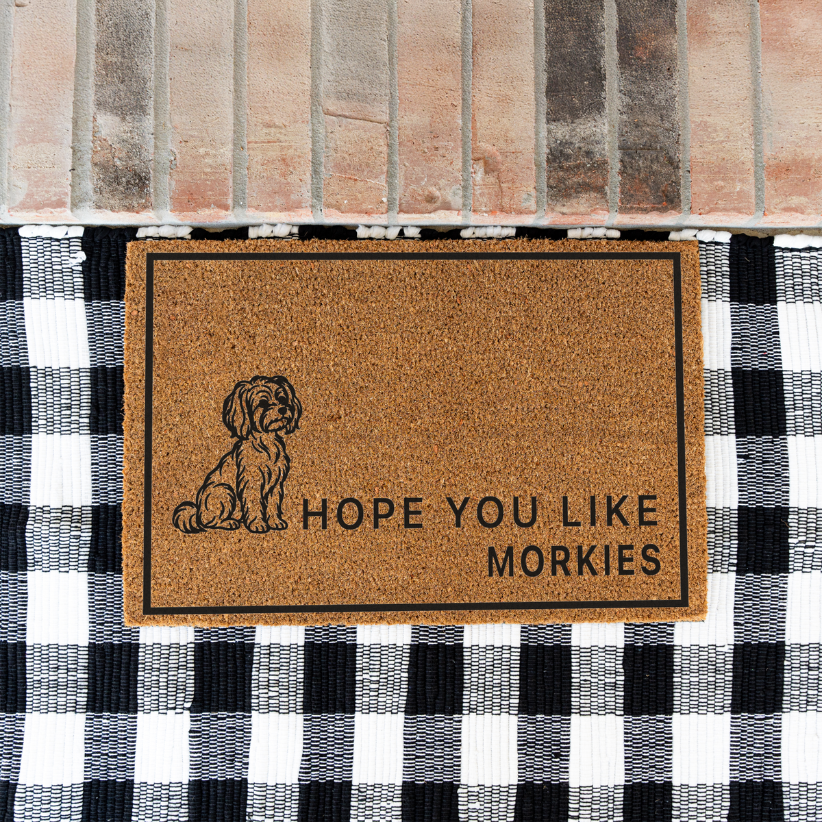 Hope You Like Morkies coir doormat with a drawing of a sitting Morkie on a black and white buffalo check rug at a brick step