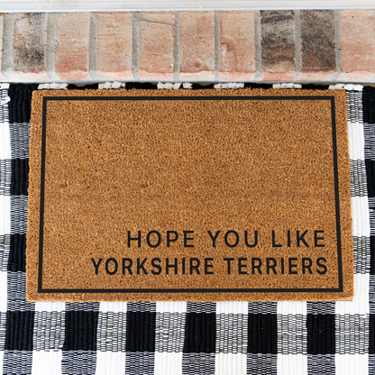 Hope You Like Yorkshire Terriers minimalist coir doormat with a thin black border on a black and white buffalo check rug, close view