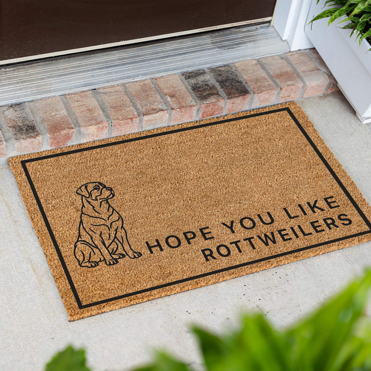 Hope You Like Rottweilers coir doormat with a drawing of a sitting Rottweiler at an angle on a front porch by a brick step