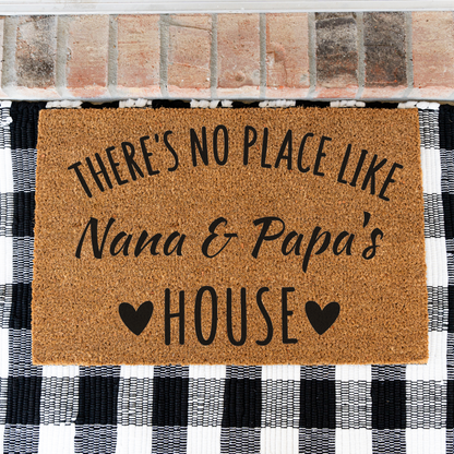 There's No Place Like Nana & Papa's House coir doormat on a black and white buffalo check rug, close view