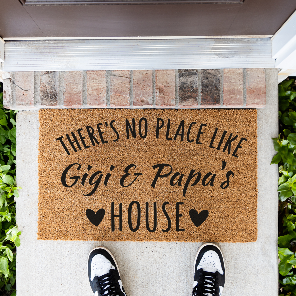 There's No Place Like Gigi & Papa's House coir doormat in front of a brick step, top-down view