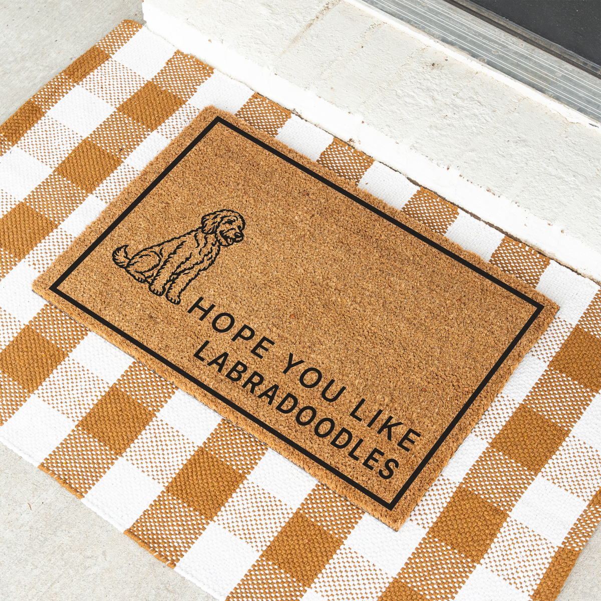 Hope You Like Labradoodles coir doormat with a drawing of a sitting Labradoodle at an angle on a tan and white check rug