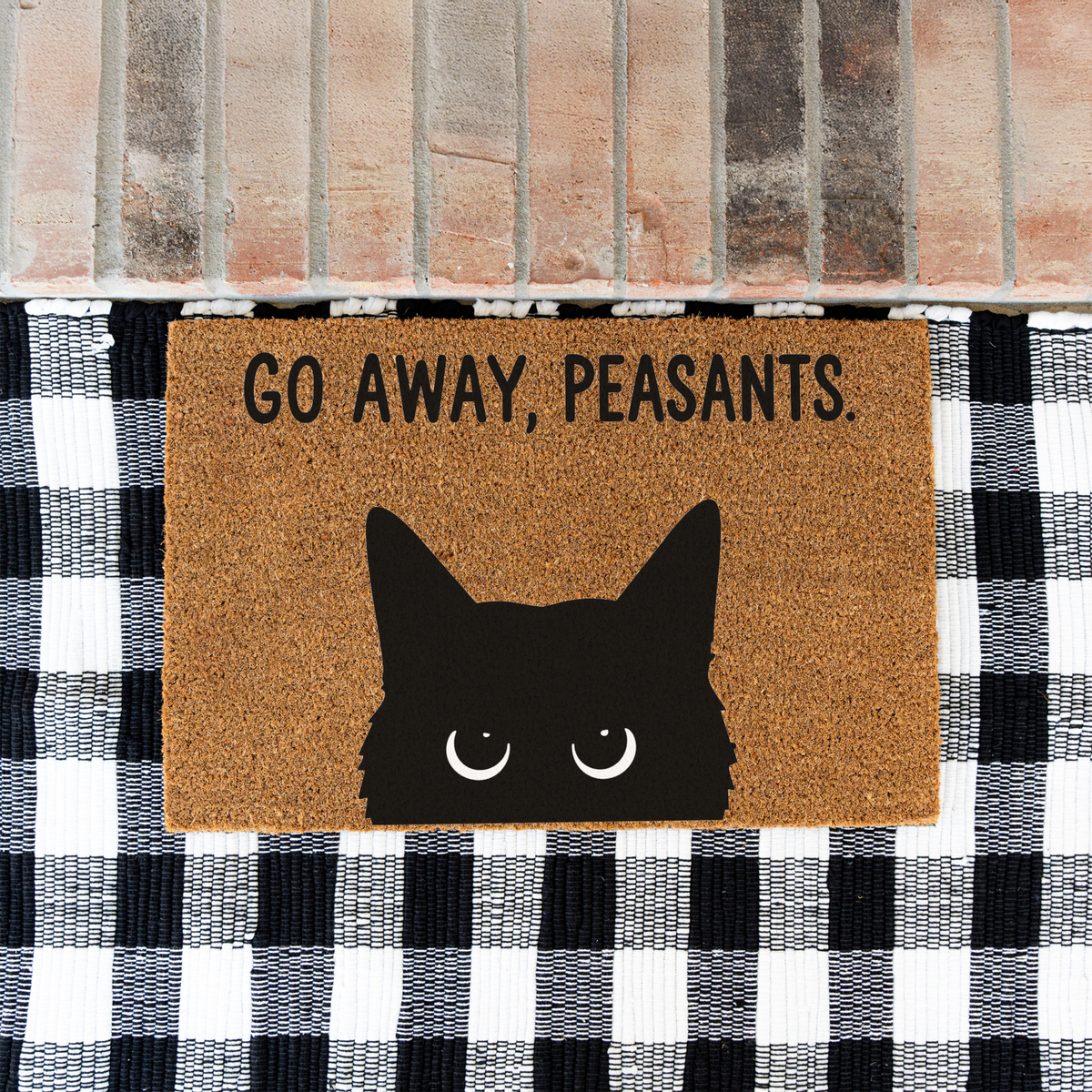 Go Away, Peasants black cat coir doormat on a black and white buffalo check rug at a brick step