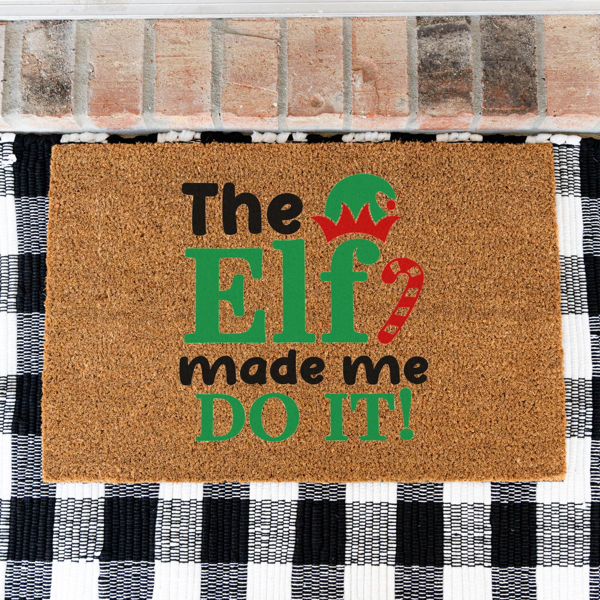 The Elf Made Me Do It coir doormat on a black and white buffalo check rug, close view