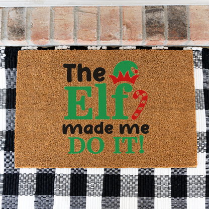 The Elf Made Me Do It coir doormat on a black and white buffalo check rug, close view