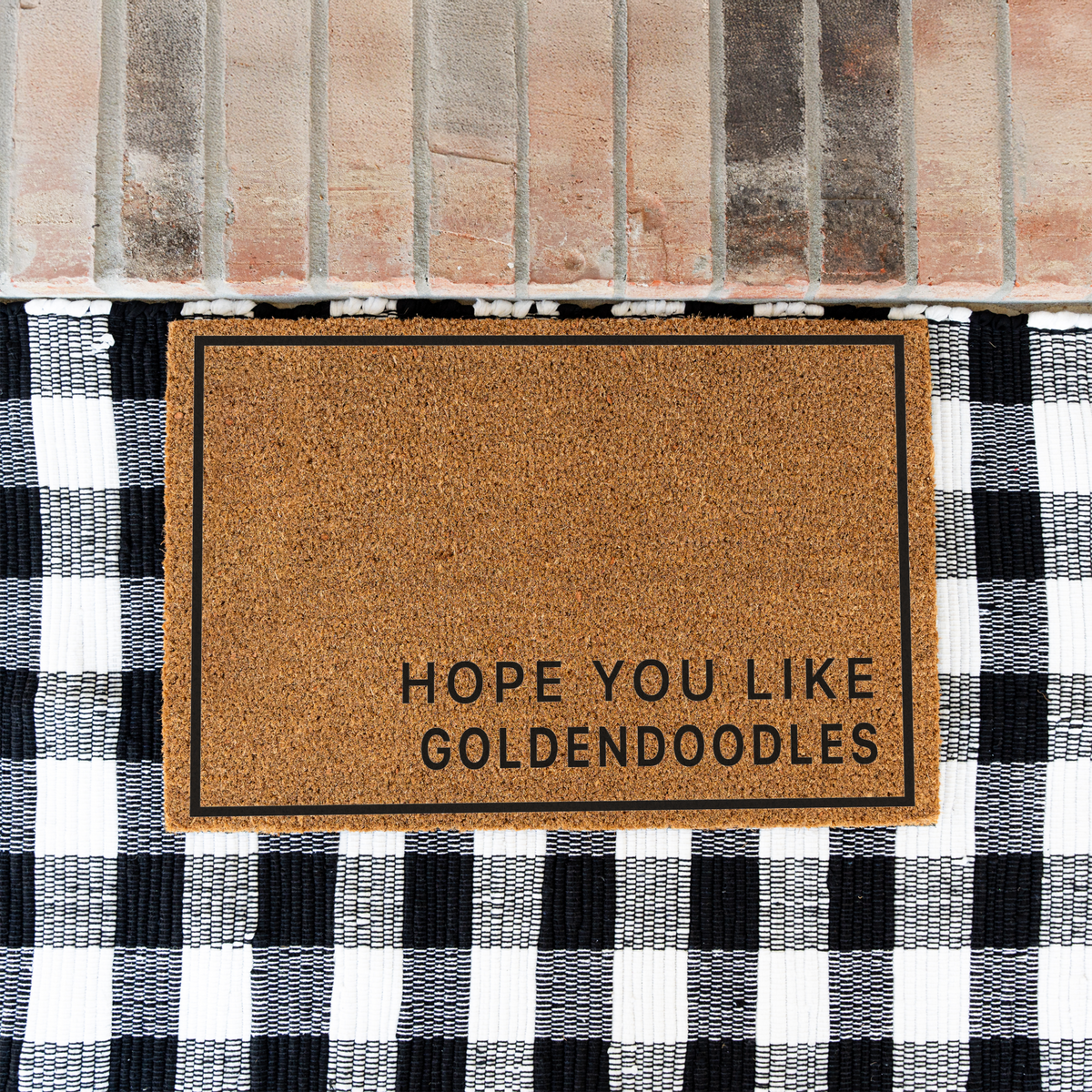 Hope You Like Goldendoodles minimalist coir doormat with a thin black border on a black and white buffalo check rug at a brick step