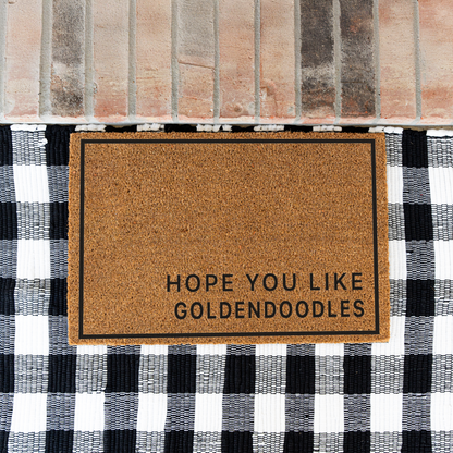 Hope You Like Goldendoodles minimalist coir doormat with a thin black border on a black and white buffalo check rug at a brick step