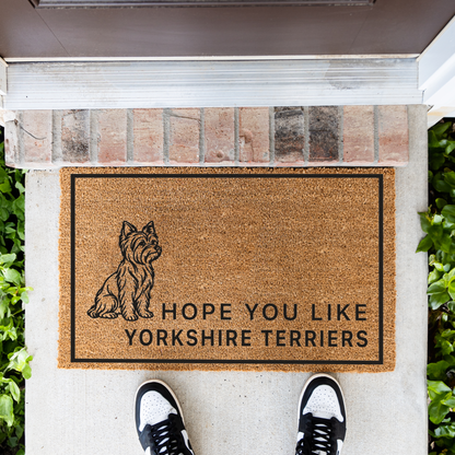 Hope You Like Yorkshire Terriers coir doormat with a drawing of a sitting Yorkshire terrier in front of a brick step, top-down view with sneakers