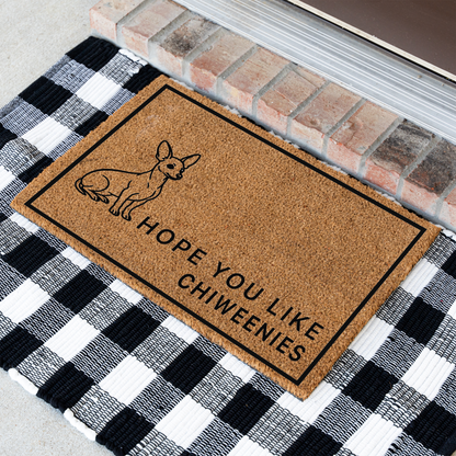 Hope You Like Chiweenies coir doormat with a drawing of a sitting Chiweenie at an angle on a black and white buffalo check rug