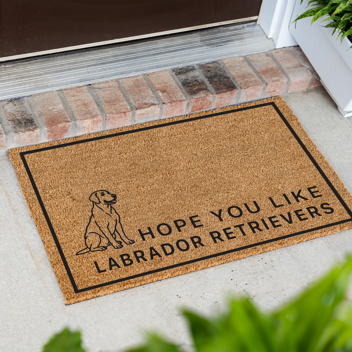 Hope You Like Labrador Retrievers coir doormat with a drawing of a sitting Labrador retriever at an angle on a front porch by a brick step