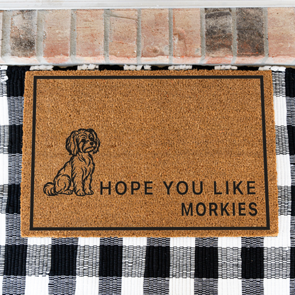 Hope You Like Morkies coir doormat with a drawing of a sitting Morkie on a black and white buffalo check rug, close view