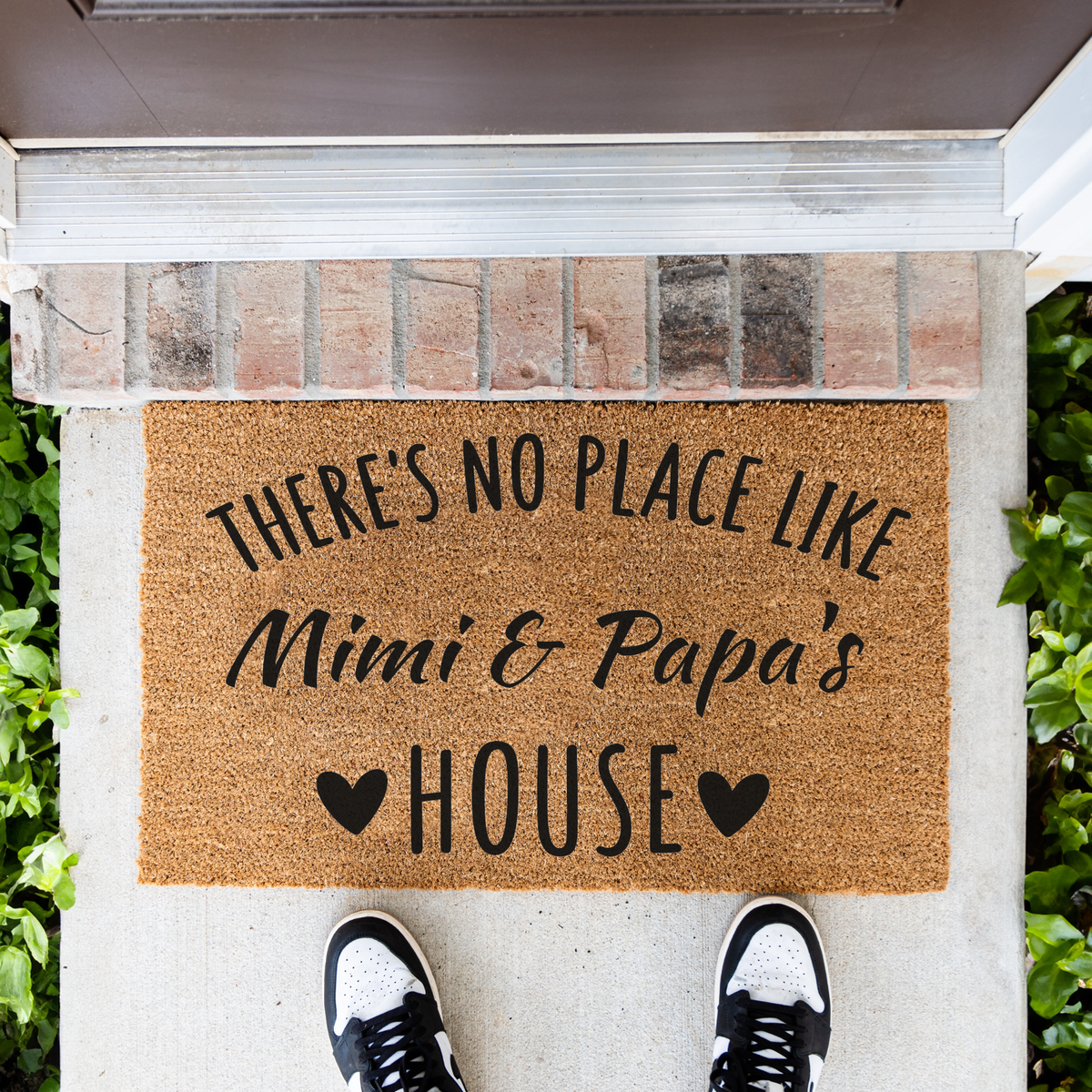 There's No Place Like Mimi & Papa's House coir doormat in front of a brick step, top-down view