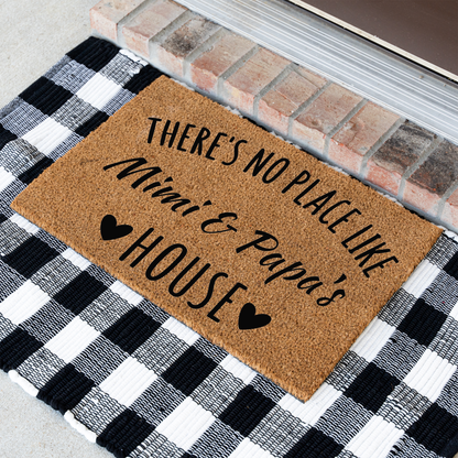 There's No Place Like Mimi & Papa's House coir doormat at an angle on a black and white buffalo check rug