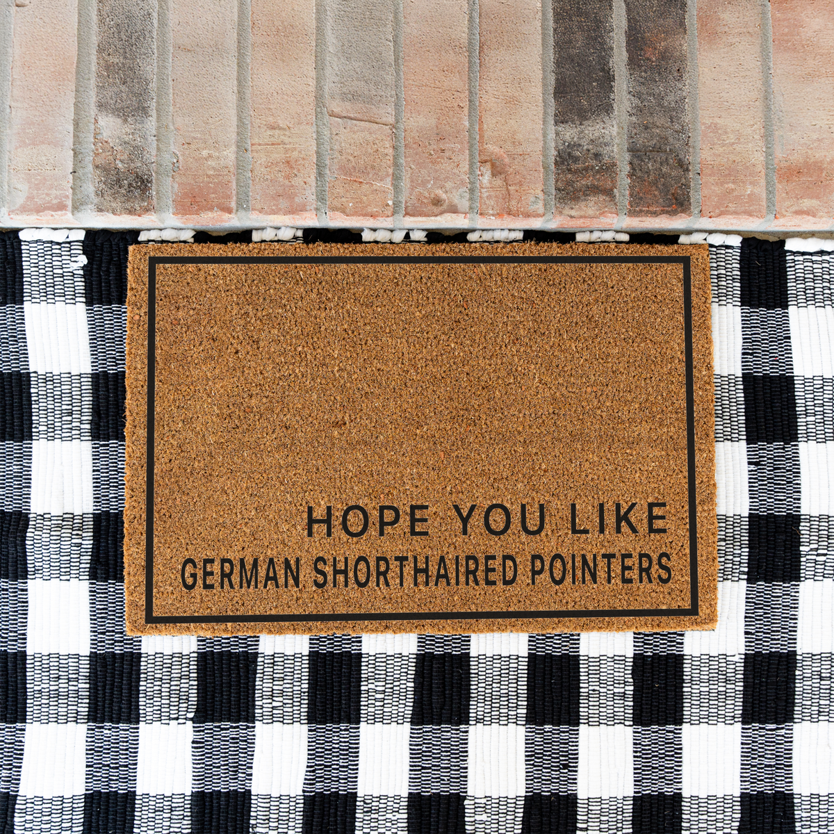 Hope You Like German Shorthaired Pointers minimalist coir doormat with a thin black border on a black and white buffalo check rug at a brick step