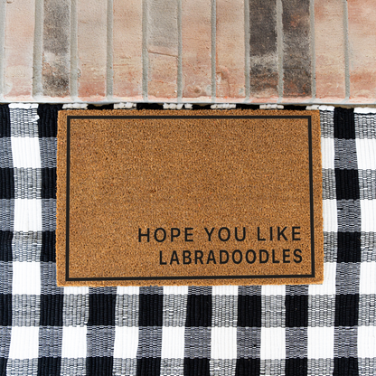 Hope You Like Labradoodles minimalist coir doormat with a thin black border on a black and white buffalo check rug at a brick step