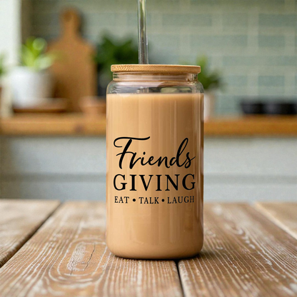 Friendsgiving 16 oz clear glass can with a bamboo lid and straw, filled with iced latte, on a kitchen counter