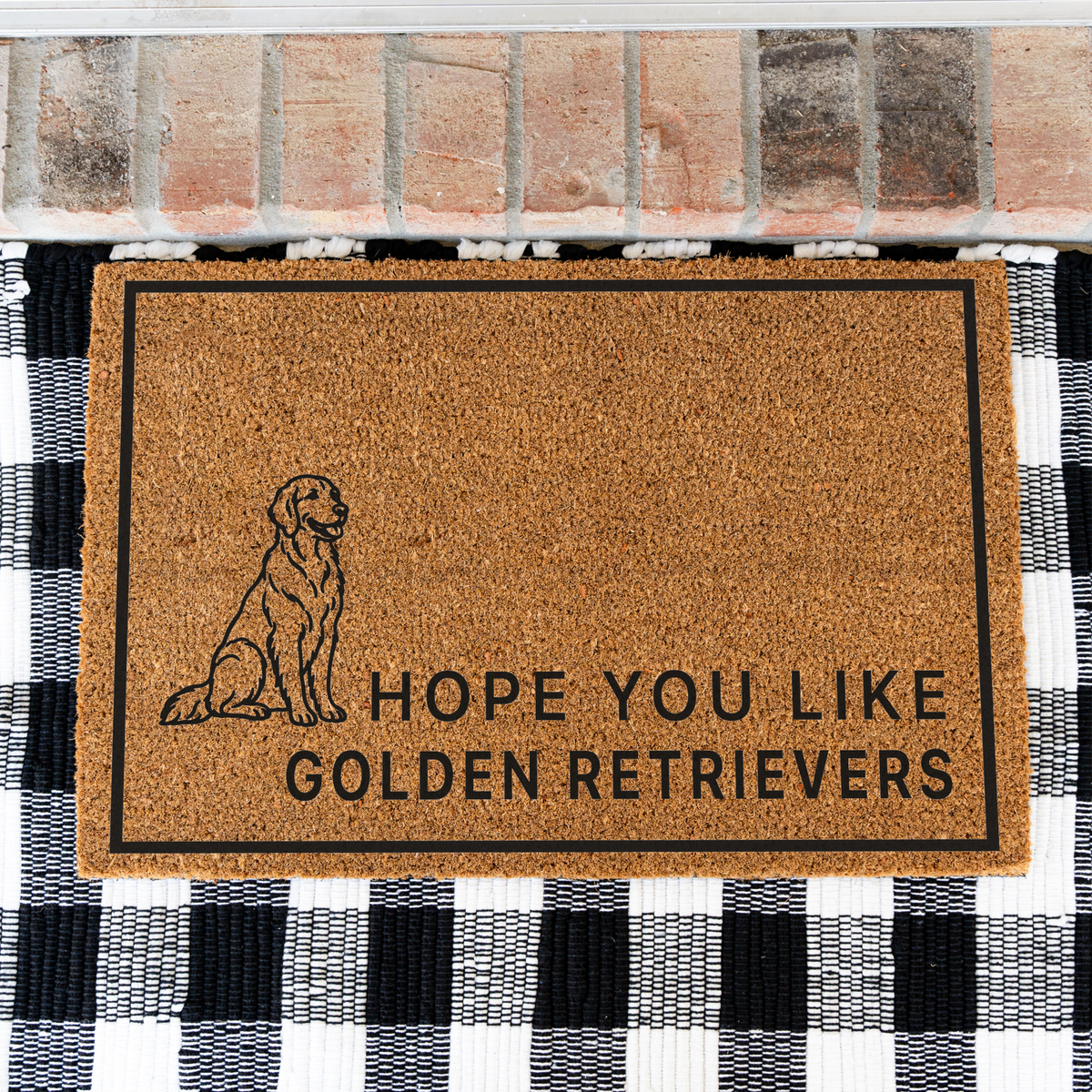 Hope You Like Golden Retrievers coir doormat with a drawing of a sitting golden retriever on a black and white buffalo check rug, close view