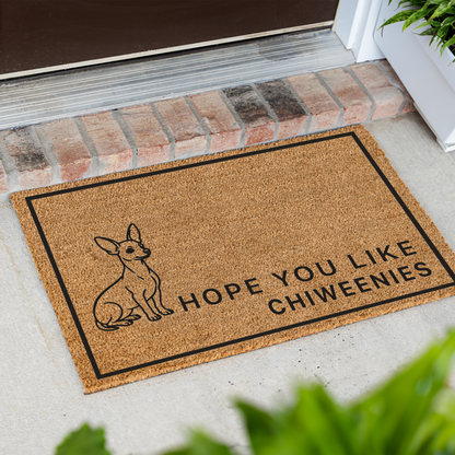 Hope You Like Chiweenies coir doormat with a drawing of a sitting Chiweenie at an angle on a front porch by a brick step