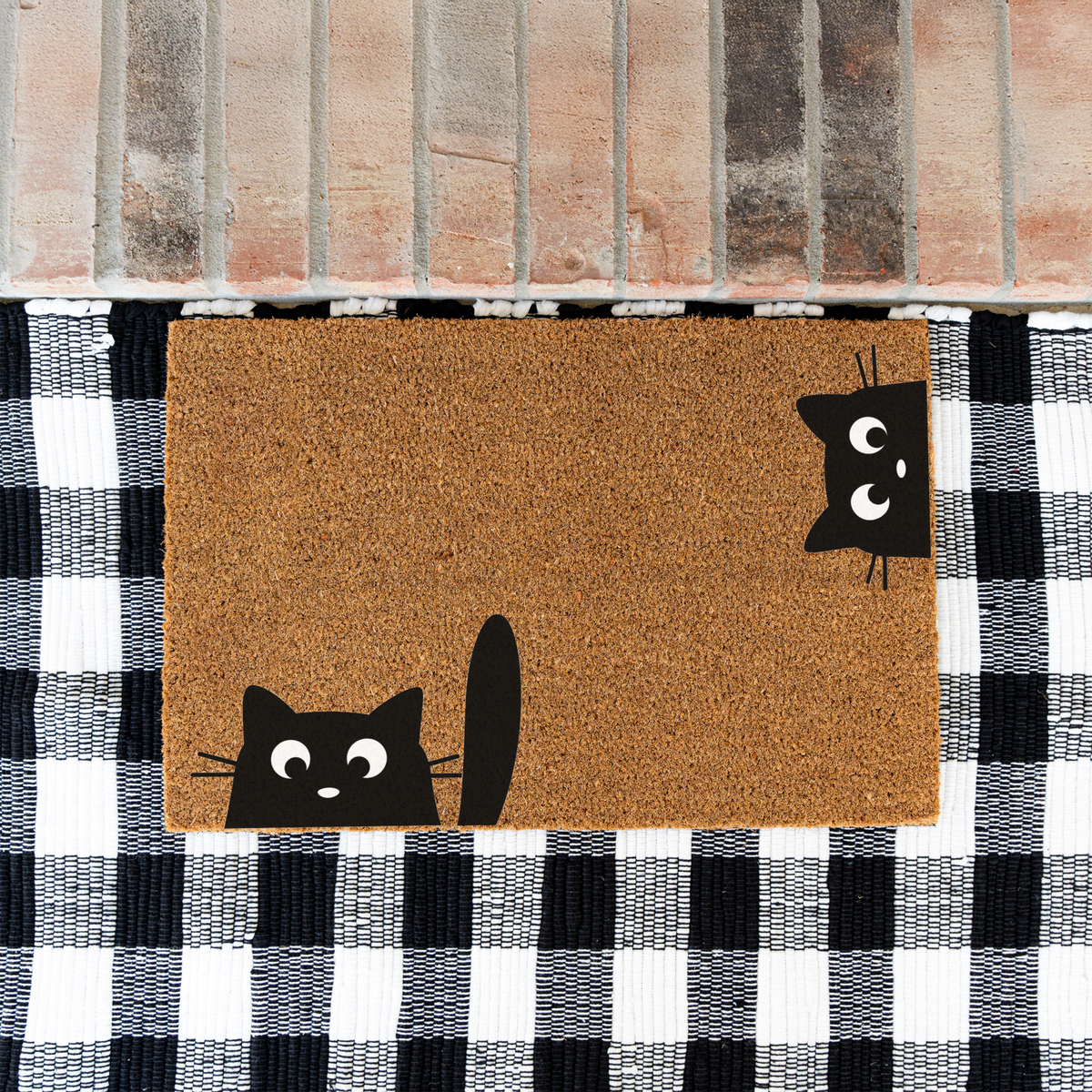 Peeking black cats coir doormat on a black and white buffalo check rug at a brick step