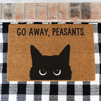 Go Away, Peasants black cat coir doormat on a black and white buffalo check rug, close view