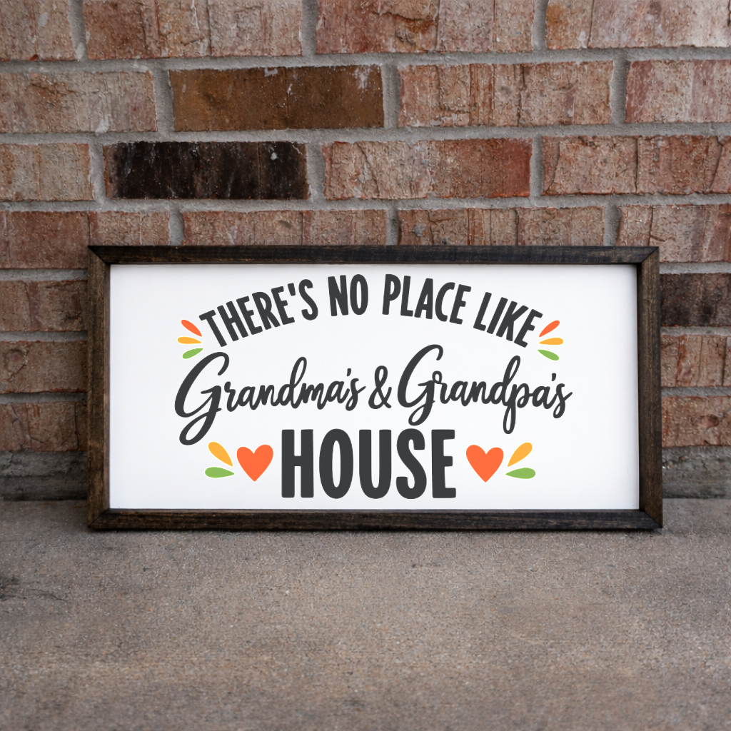 There's No Place Like Grandma's & Grandpa's House wide framed sign with a walnut frame leaning on a brick wall