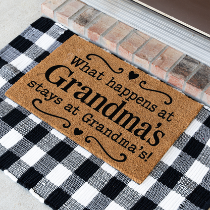 What Happens at Grandma's Stays at Grandma's coir doormat with hearts at an angle on a black and white buffalo check rug