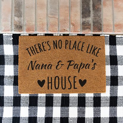 There's No Place Like Nana & Papa's House coir doormat on a black and white buffalo check rug at a brick step