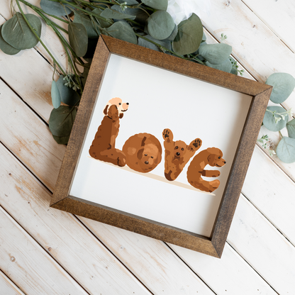 Four red doodles spelling LOVE square framed sign with a walnut frame on white wood planks with eucalyptus