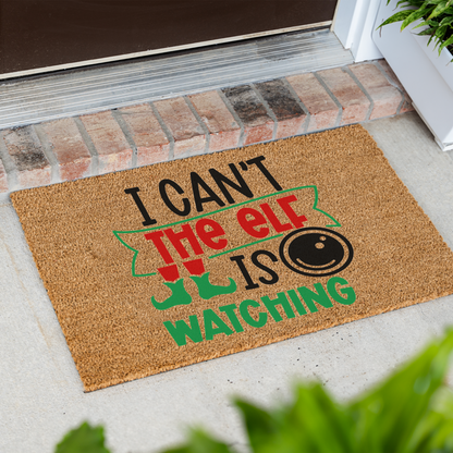 I Can't The Elf Is Watching coir doormat at an angle in front of a brick step