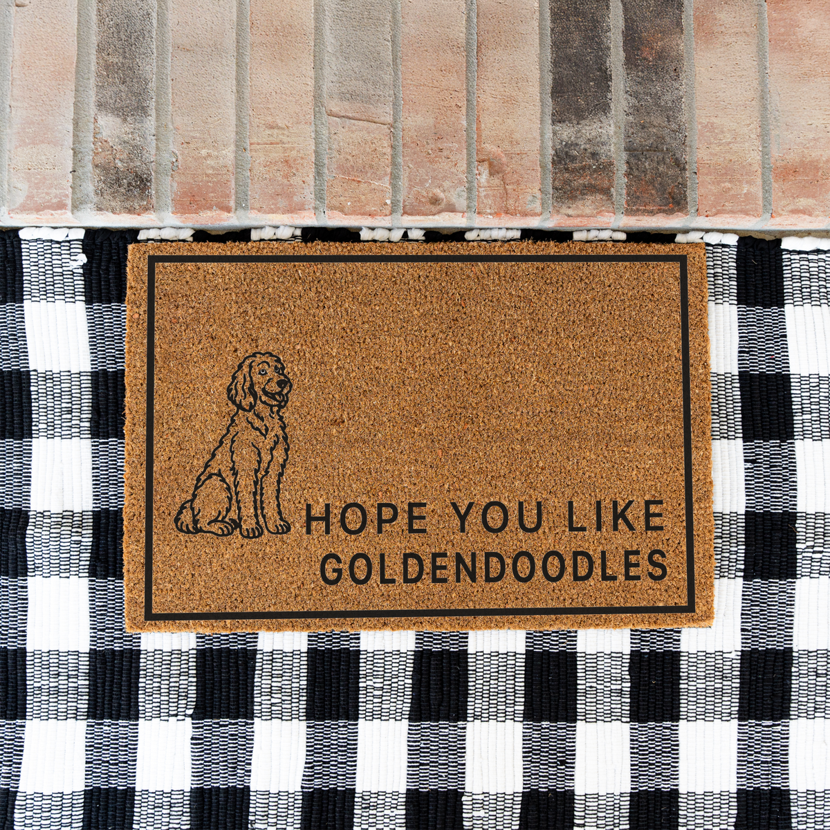 Hope You Like Goldendoodles coir doormat with a drawing of a sitting Goldendoodle on a black and white buffalo check rug at a brick step