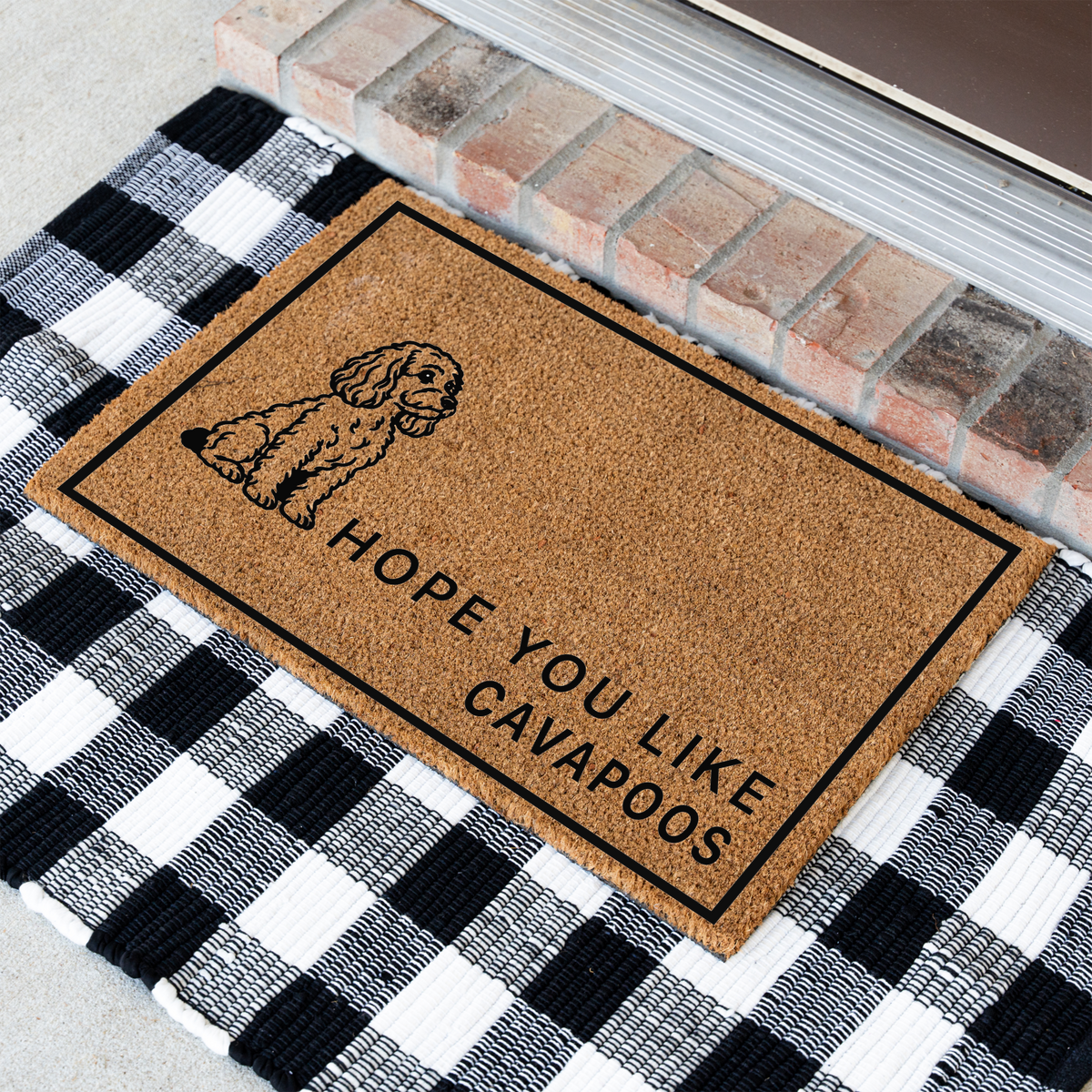 Hope You Like Cavapoos coir doormat with a drawing of a sitting Cavapoo at an angle on a black and white buffalo check rug