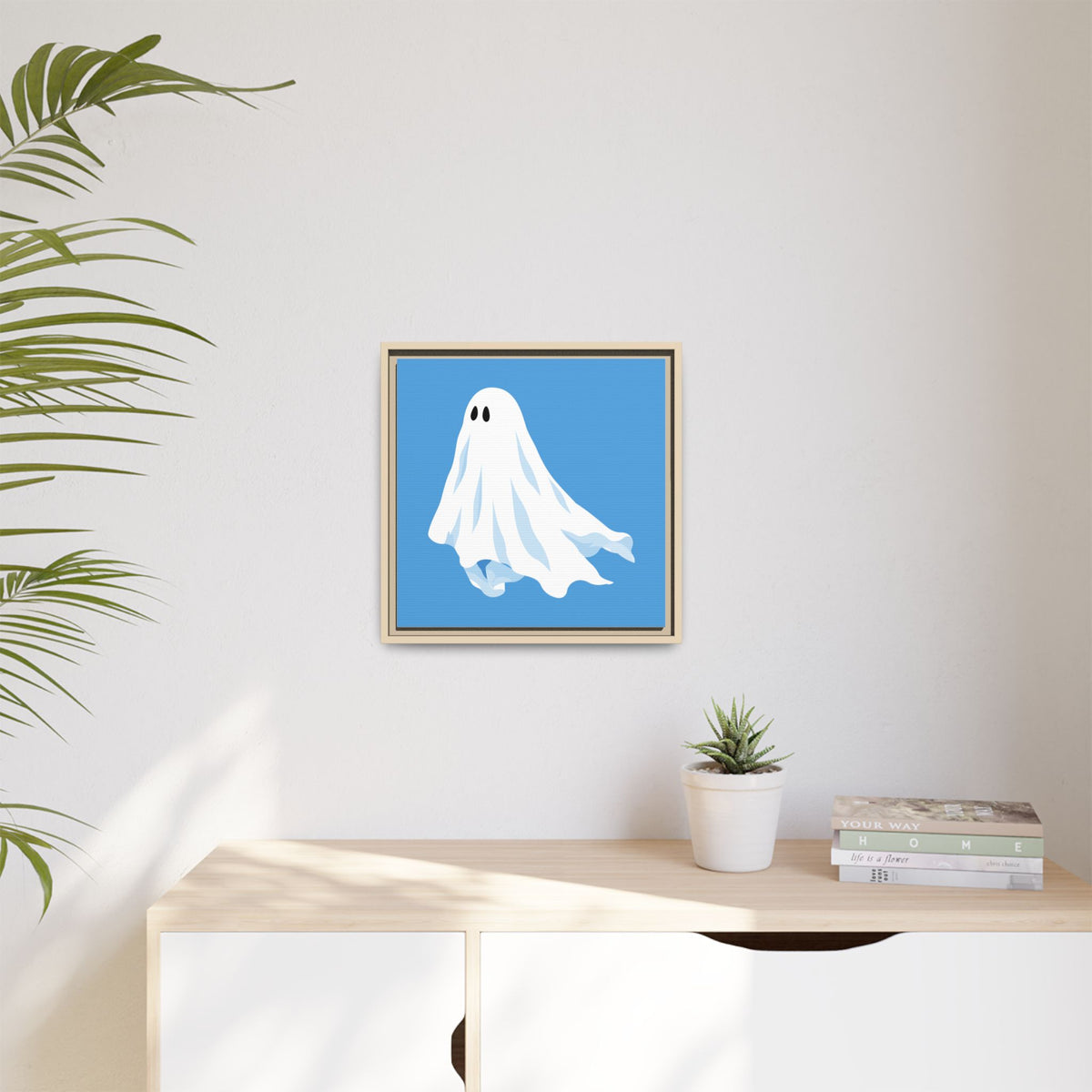Blue ghost canvas print in a natural frame on a light living room wall
