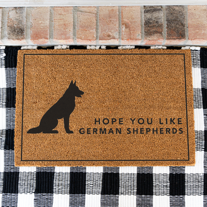 Hope You Like German Shepherds silhouette coir doormat with a thin black border on a black and white buffalo check rug, close view