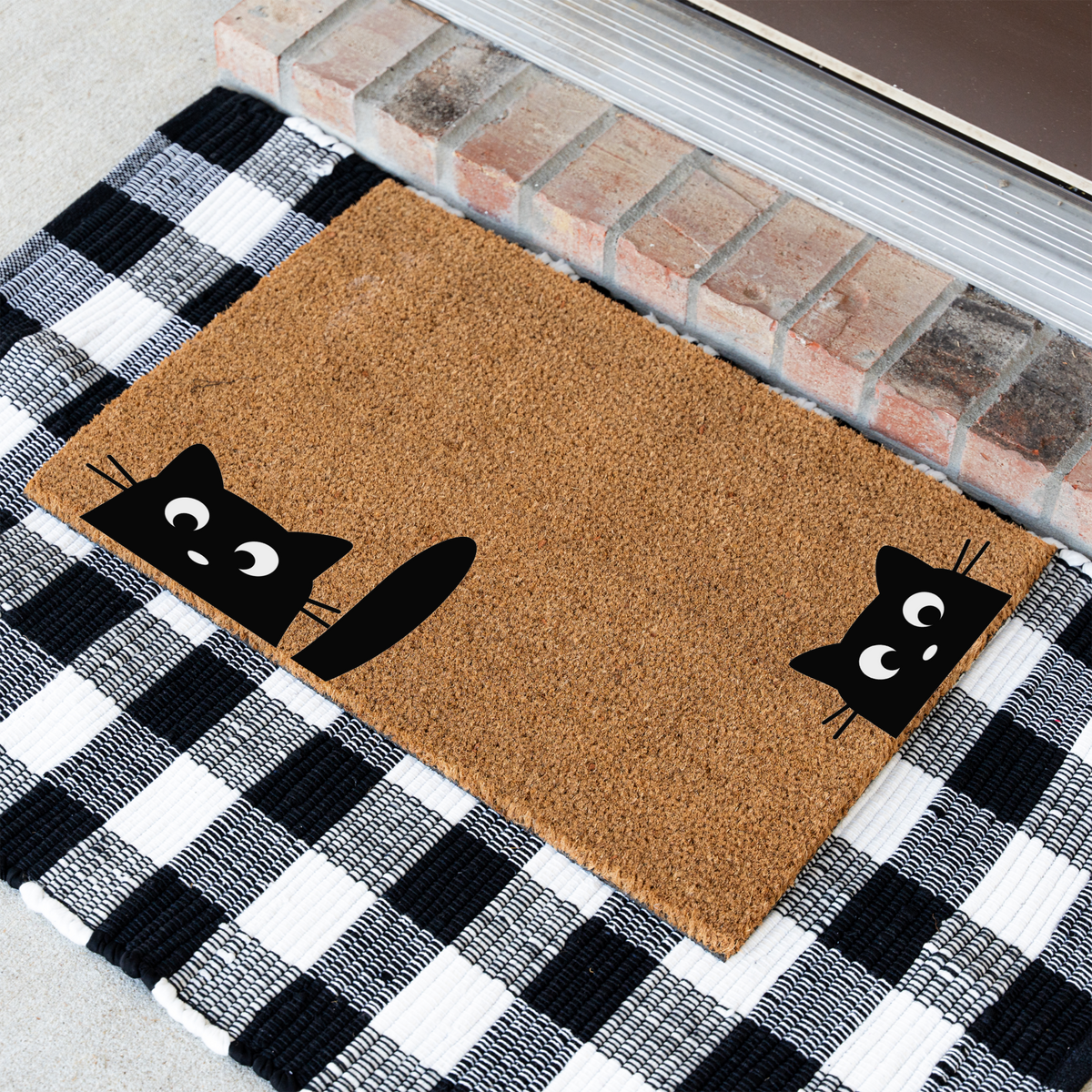 Peeking black cats coir doormat at an angle on a black and white buffalo check rug