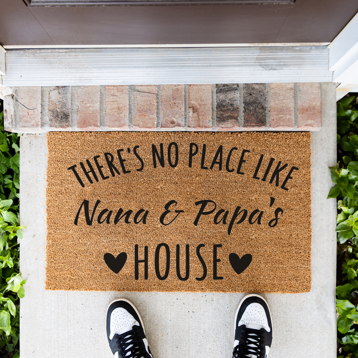 There's No Place Like Nana & Papa's House coir doormat in front of a brick step, top-down view