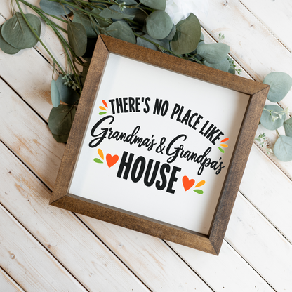 There's No Place Like Grandma's & Grandpa's House square framed sign with a walnut frame on white wood planks with eucalyptus