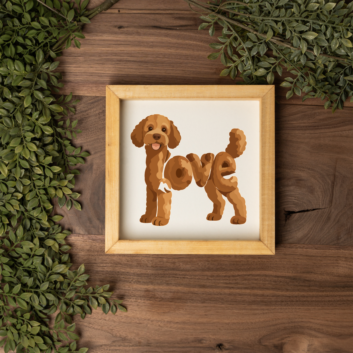 Standing red doodle love square framed sign with a natural wood frame on a dark wood table with greenery