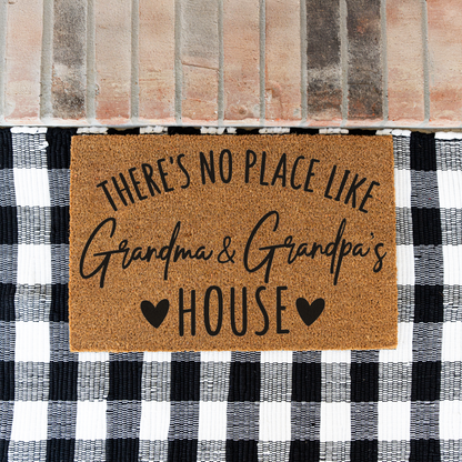 There's No Place Like Grandma & Grandpa's House coir doormat on a black and white buffalo check rug at a brick step